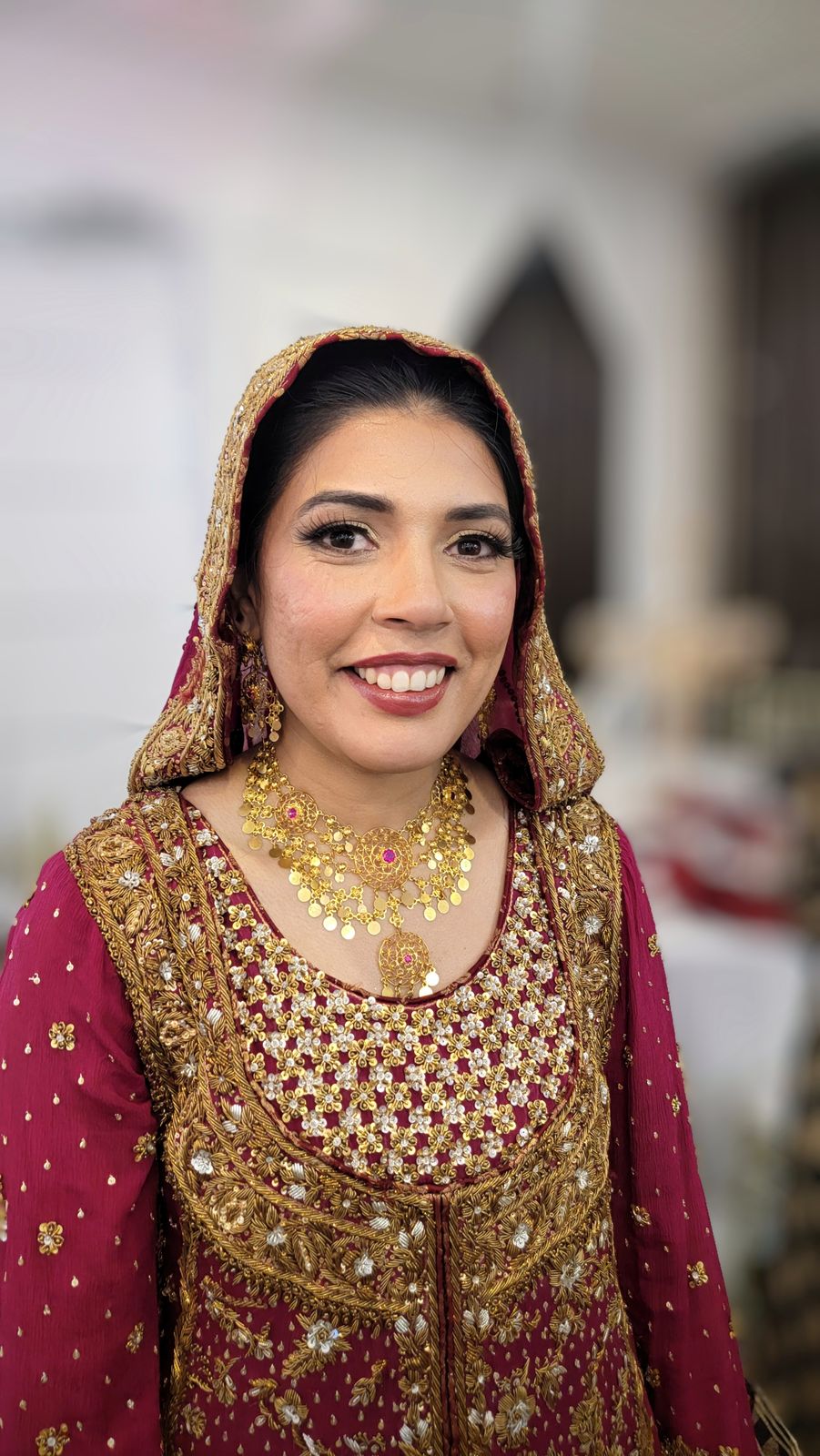 Bride in a red dupatta and gold jewellery